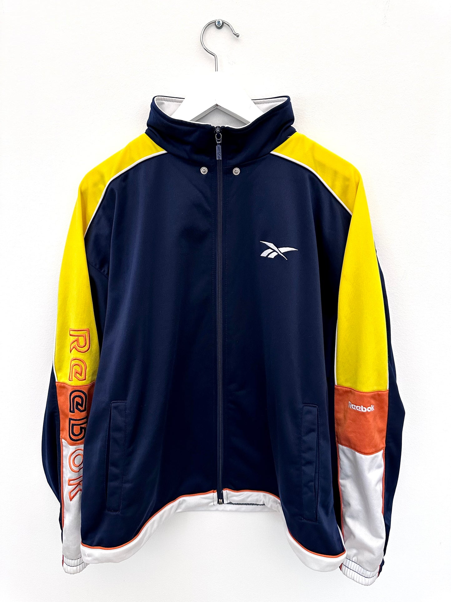 Navy and yellow vintage jacket with Reebok logo on a white background