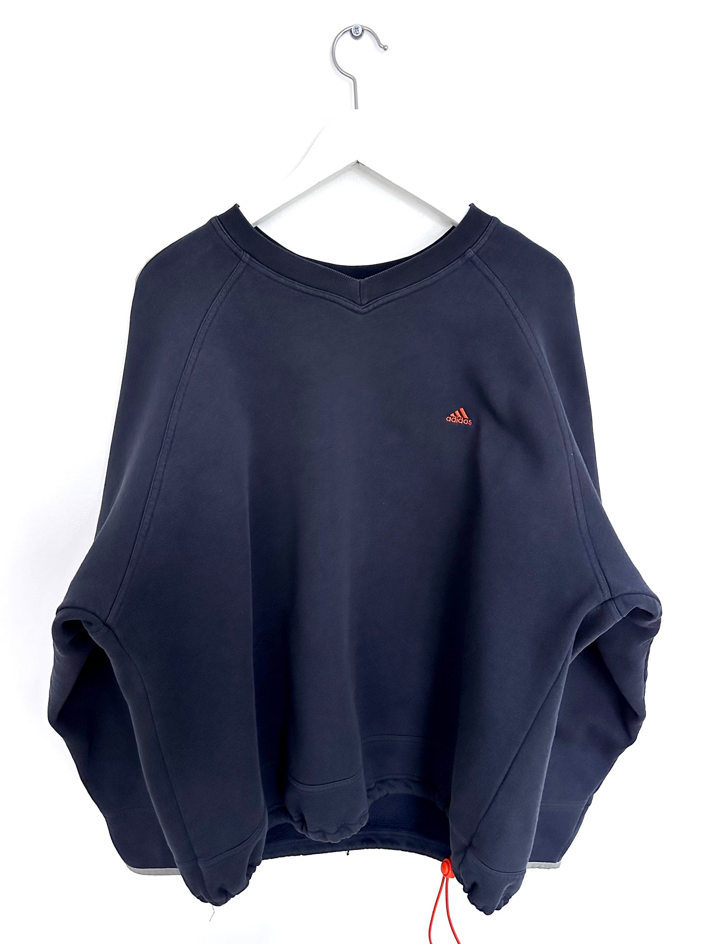 Navy blue vintage sweatshirt with a orange Adidas logo on a white hanger