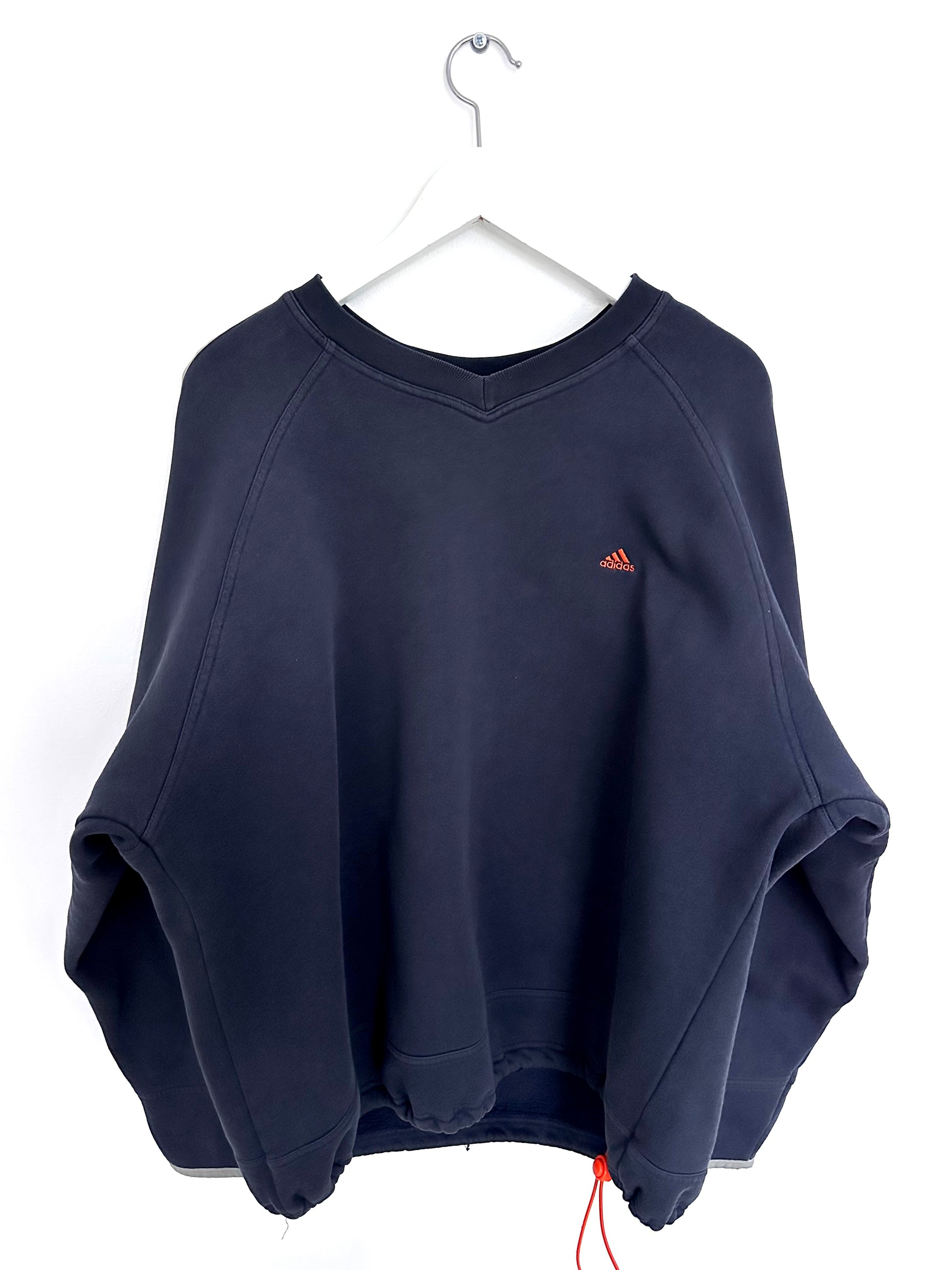 Navy blue vintage sweatshirt with a orange Adidas logo on a white hanger